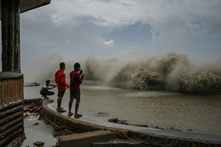 Residents take pictures of waves lashing a shoreline after Cyclone Yaas hit India's eastern coast in the Bay of Bengal in Digha, about 190 kilometres from Kolkata