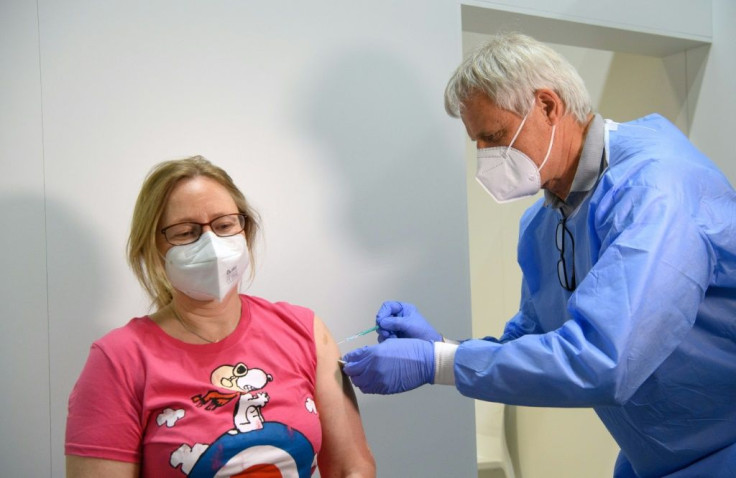 Doctor Christoph Borch vaccinates a woman at Babelsberg vaccination centre in Potsdam outside Berlin as Germany looks to extend inoculations to children over 12