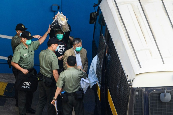 Pro-democracy activists Leung Kwok-hung (centre L), also known as 'Long Hair' and Lee Cheuk-yan (centre R) walk to a Hong Kong Correctional Services van before being driven to the District Court