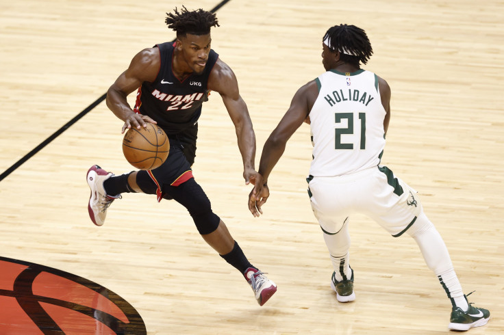 Jimmy Butler #22 of the Miami Heat dribbles up the court defended by Jrue Holiday #21 of the Milwaukee Bucks