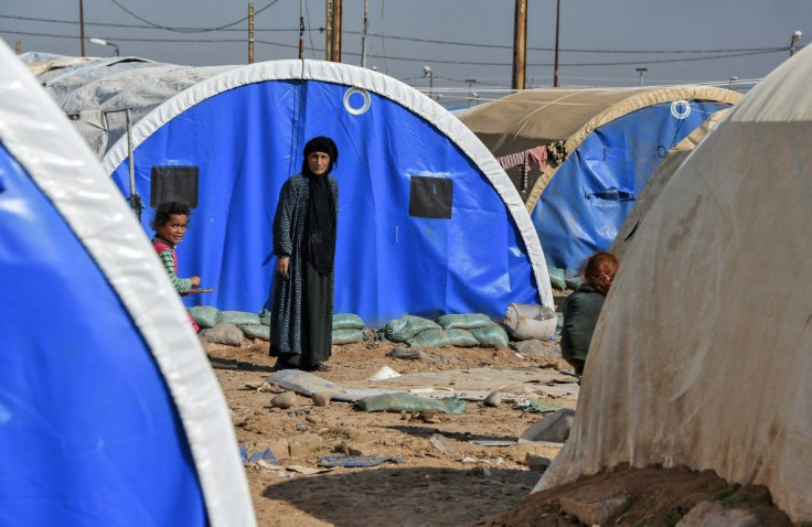 A woman and child are seen outside tents in Al-Jadaa camp on the outskirts of Qayyarah, south of the Iraqi city of Mosul, in this file picture taken on February 11, 2021