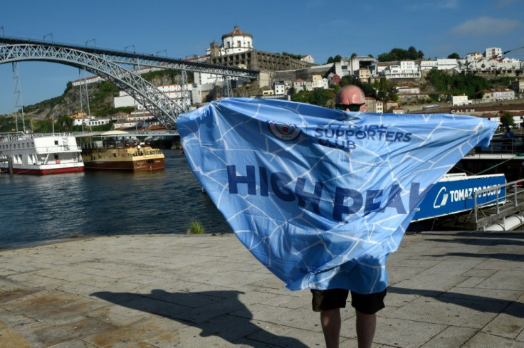 A Manchester City supporter shows his colours with Porto's famous Dom Luis bridge the backdrop