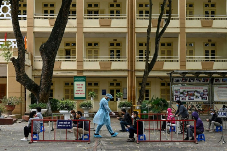People in Hanoi wait to be tested for Covid-19 at a makeshift testing centre near Bach Mai Hospital