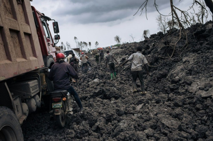 People try to make their way through solidified lava in the DR Congo city of Goma after last Saturday's volcanic eruption