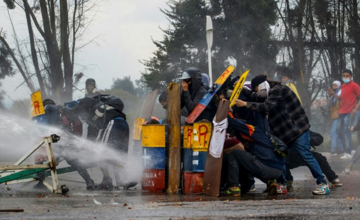 Demonstrators stand behind makeshift shields during clashes with riot police in the city of Madrid, Colombia, on May 28, 2021 as anti-government protests continued across the country