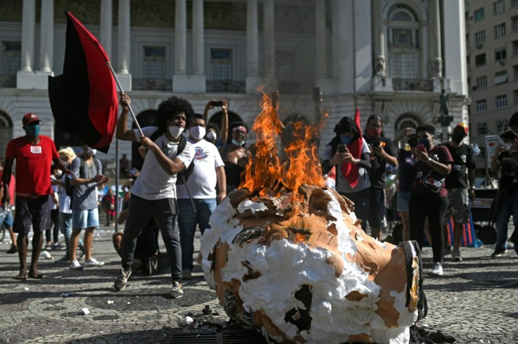 Demonstrators in Brazil burn a doll representing President Jair Bolsonaro during a rally in Rio de Janeiro on May 29, 2021