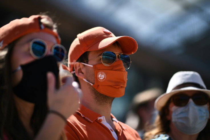 Cover up: Spectators wearing protective face masks at Roland Garros on Sunday