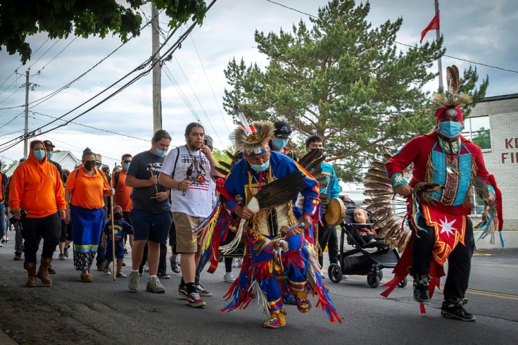 Members of the community of the Kahnawake Mohawk Territory, Quebec march through the town on May 30, 2021, to commemorate the news that a mass grave of 215 Indigenous children were found at the Kamloops Residential School in British Columbia, Canada