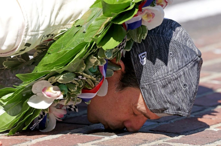 Helio Castroneves kisses the bricks at the finish line after winning the Indianapolis 500