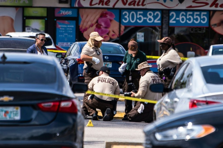 Miami Dade police officers collect evidence from the parking lot outside the hall that was the scene of the shooting