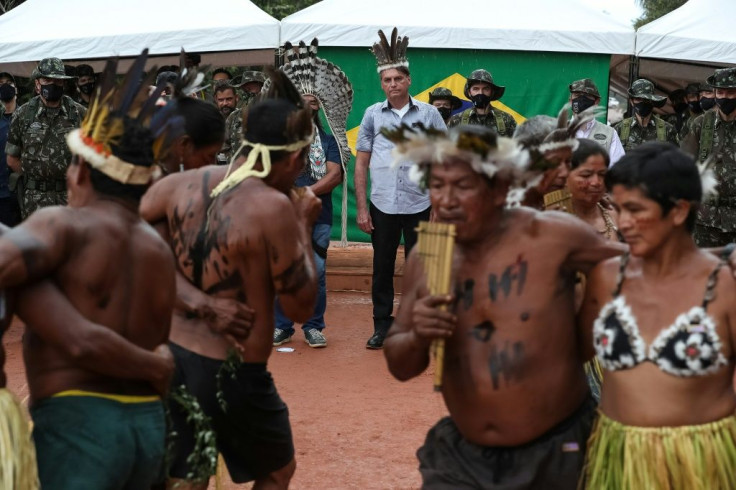 Handout file photo taken on May 27, 2021 released by the Brazilian Presidency showing President Jair Bolsonaro (C) watching an indigenous celebration