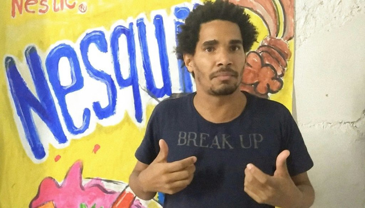 In this grab from an AFPTV video Cuban artist and dissident Luis Manuel Otero Alcantara gestures in front of one of his paintings in Havana on April 4, 2021