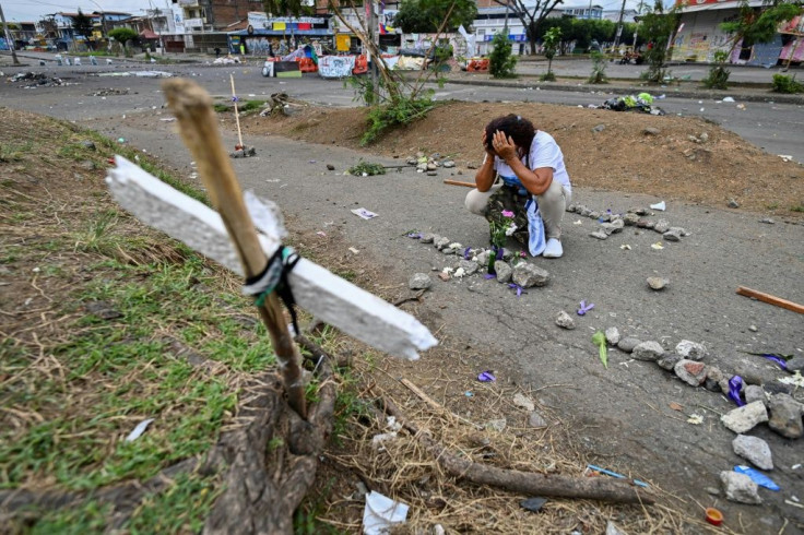 A woman cries at the grave of a protester killed during clashes between anti-government demonstrators and police in Cali