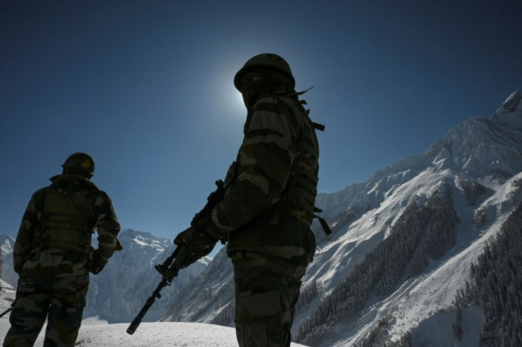 Indian soldiers walk along a road near Zojila mountain pass that connects Srinagar to the union territory of Ladakh, bordering China
