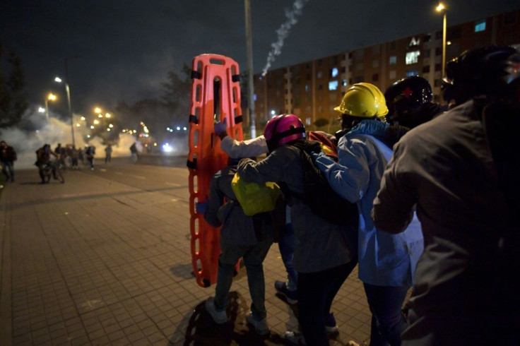 Volunteers have had to use stretchers as shields as they tend to the fallen in clashes between protesters and police in Colombia