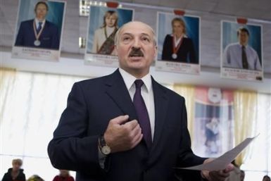 Belarussian President Alexander Lukashenko speaks to the media at a polling station during local election in Minsk
