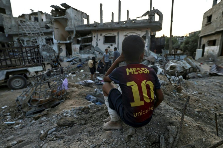 A Palestinian boy sits near residential buildings destroyed during recent Israeli strikes, on June 1, 2021, in the northern Gaza Strip, more than a week after a ceasefire brought an end to 11 days of hostilities between Israel and Gaza rulers Hamas