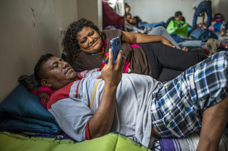 Eloy Camarillo Salazar and Saturina Patricio Gonzales pass the time by watching a video at the Matamoros migrant shelter