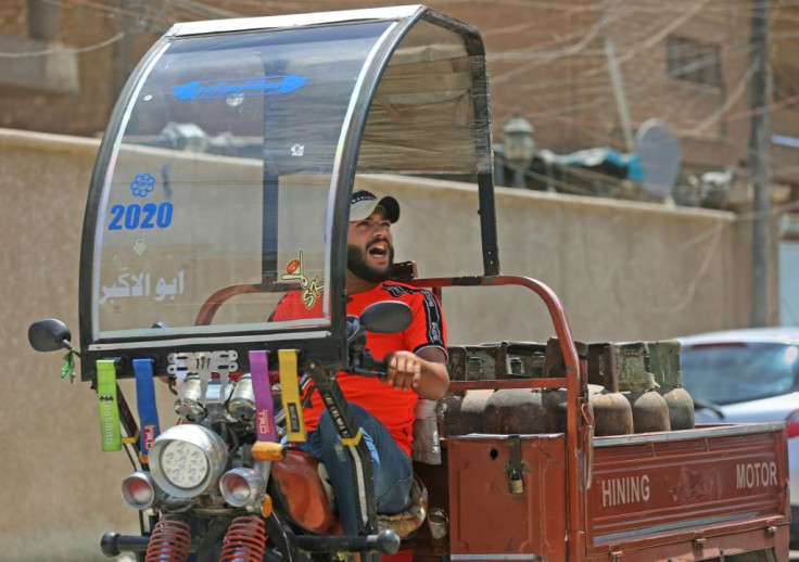 Deliveryman Mountazar Abbas announces the arrival of his cylinder-laden rickshaw by singing in the Karrada district of Iraq's capital Baghdad