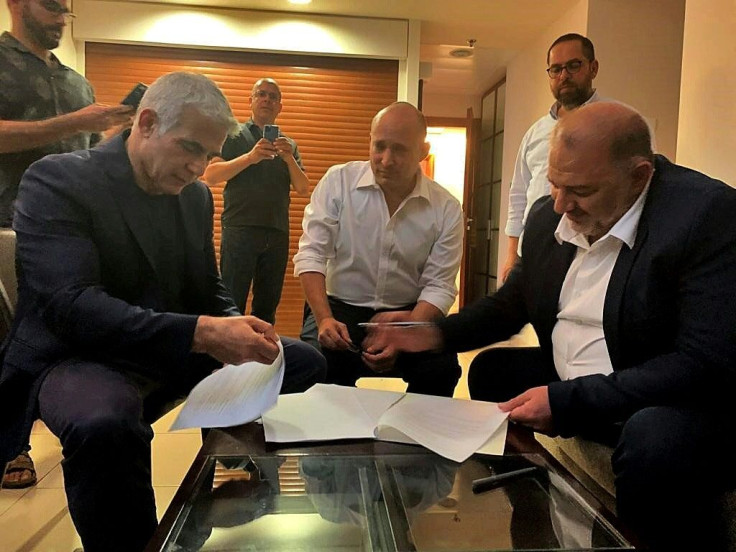 Unlikely bedfelllows - Arab Israeli Raam Mansour, leader of the Islamic conservative party Raam, signs the coalition agreement with opposition leader Yair Lapid and Jewish settler champion Naftali Bennett