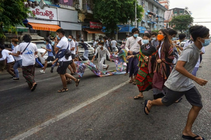 Protesters run from security forces during a demonstration against the military coup in Yangon on June 3, 2021
