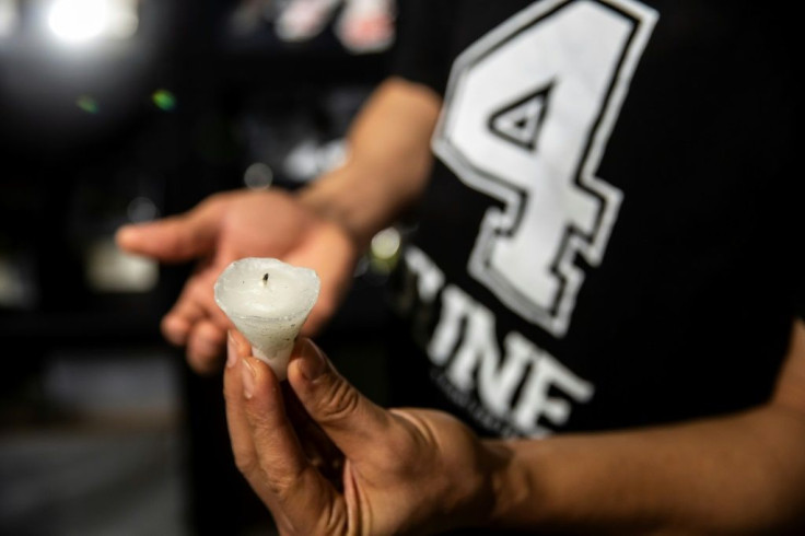 Hong Kong artist Kacey Wong holds a used candle stub collected from a previous Tiananmen vigil -- the 2021 event has been banned
