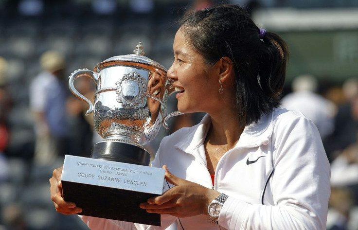 China's Li Na kisses the trophy after winning the 2011 French Open but a decade on she cuts a muted figure in China and has stopped posting on social media