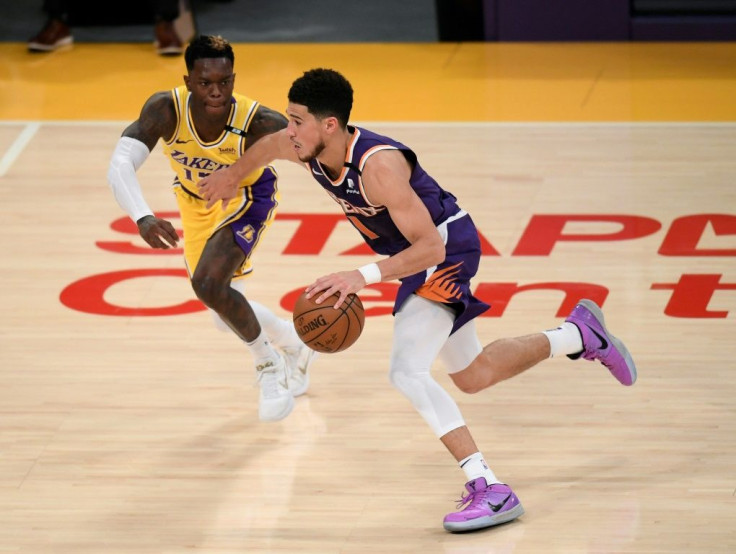 Phoenix's Devin Booker drives past Los Angeles guard Dennis Schroder in the Suns' 113-100 victory over the Lakers that clinched their NBA playoffs first-round series