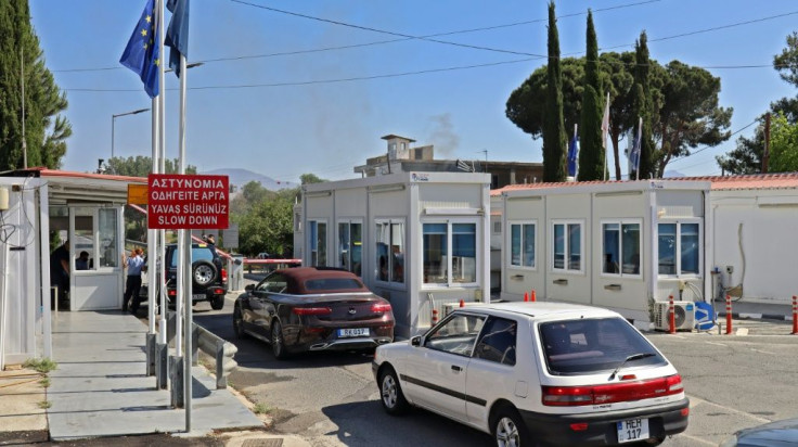 Vehicles pass through the Agios Dometios/Metehan crossing in the Cypriot capital Nicosia heading towards the breakway Turkish Cypriot north