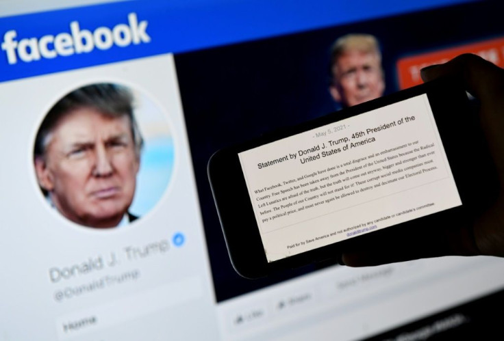 In this file photo illustration, a phone screen displays the statement of former US president Donald Trump on his Facebook page background