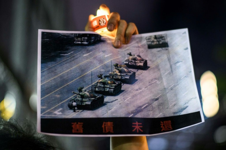 A man holds a poster of the "Tank Man" photo during a candlelit remembrance in Hong Kong's Victoria Park on June 4, 2020