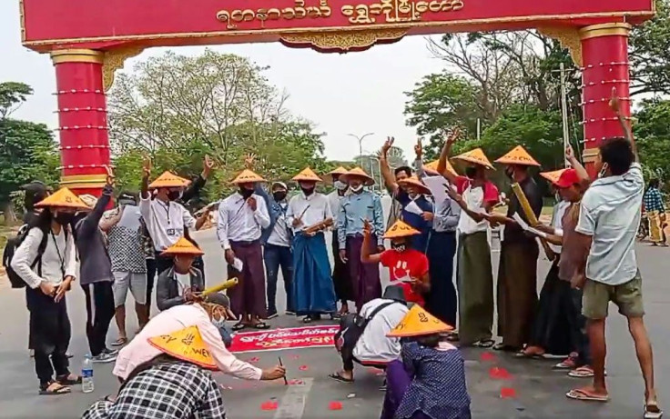 Protesters make the three-finger salute during a poetry reading in the city of Shwebo