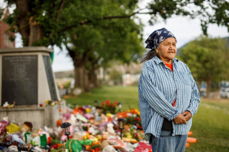 Kamloops Indian Residential School survivor Evelyn Camille, 82, poses next to a makeshift memorial at the former Kamloops Indian Residential School to honour the 215 children whose remains have been discovered buried near the facility, in Kamloops, Britis