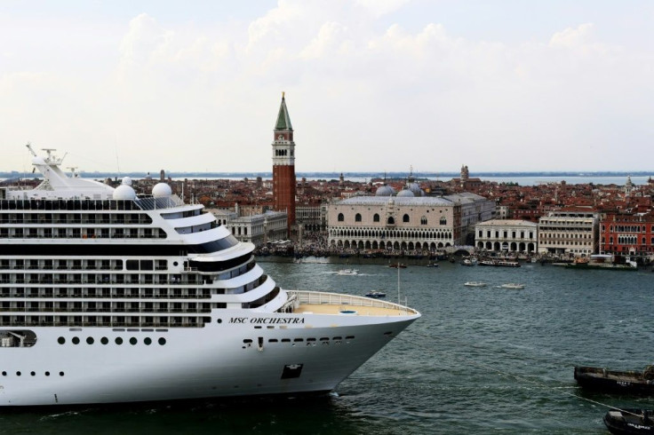 Tugboats escort the MSC Orchestra cruise ship across the basin past the Bell Tower and the Doge's palace