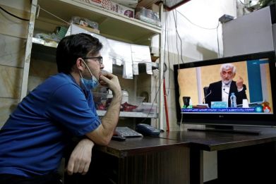 An Iranian man watches the first presidential candidates' debate at a shop in Tehran on June 5, 2021. Iranians are set to elect a successor to President Hassan Rouhani on June 18