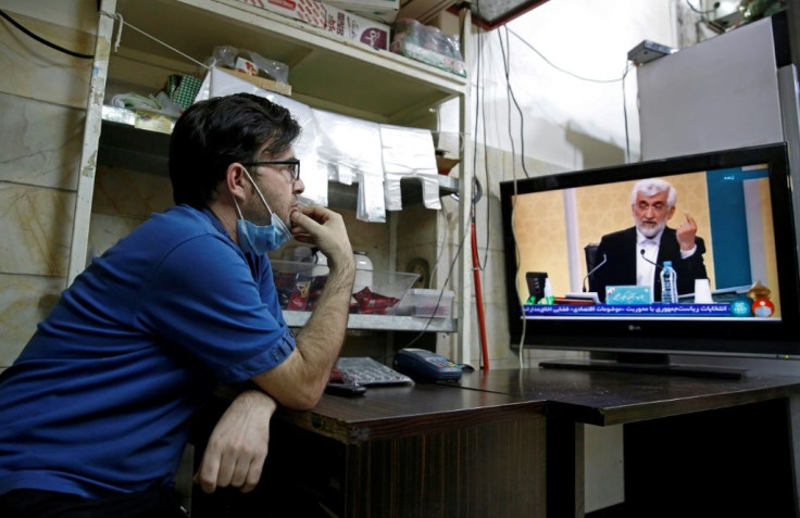 An Iranian man watches the first presidential candidates' debate at a shop in Tehran on June 5, 2021. Iranians are set to elect a successor to President Hassan Rouhani on June 18