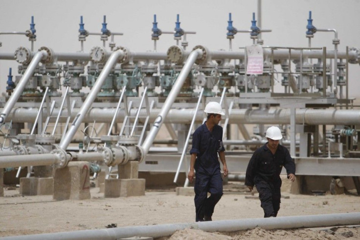 Workers walk at Rumaila oilfield in Basra, 420 km (260 miles) southeast of Baghdad