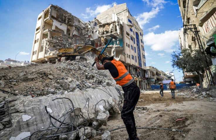 A Palestinian workman breaks rubble from a Gaza City building destroyed during the May conflict between Hamas and Israel