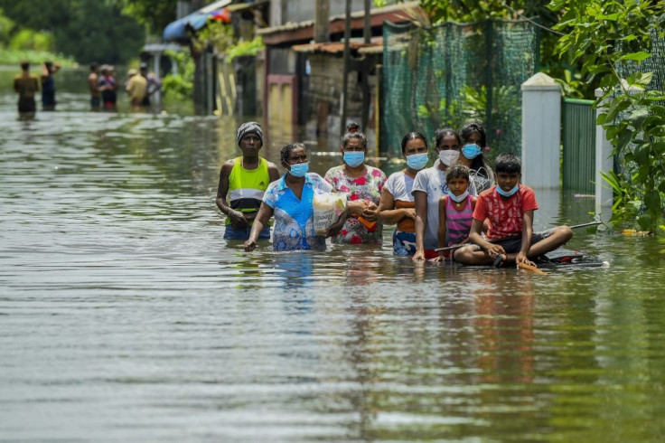 Residents make their way through floodwaters after heavy monsoon rains in Kelaniya