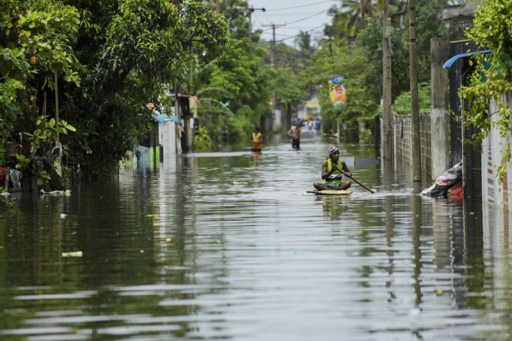 A man uses a makeshift raft to negotiate floodwaters after heavy monsoon rains in Kelaniya