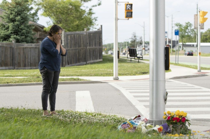 A woman pays her respects at the scene where a man driving a pickup truck struck and killed four members of a Muslim family in London, Ontario, Canada
