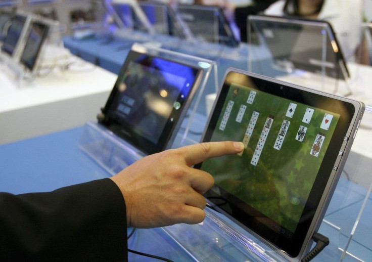 A visitor plays with a tablet PC at the Intel booth during the Computex 2011 computer fair at the TWTC Nangang exhibition hall in Taipei