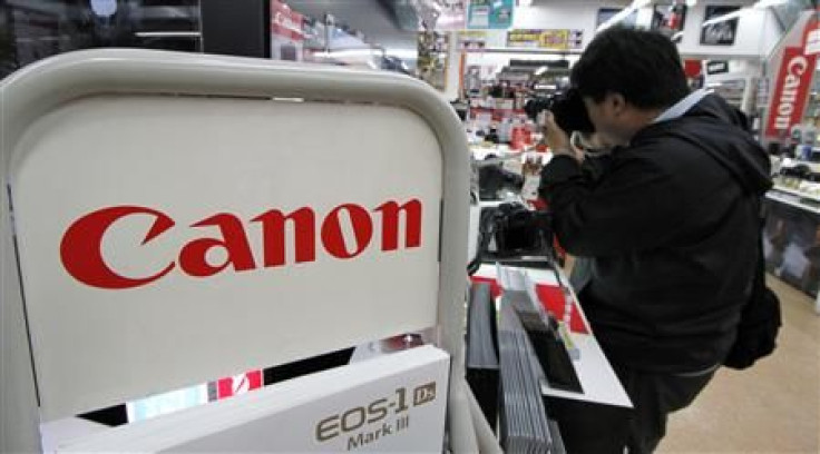 Man tests a Canon camera at an electronic shop in Tokyo