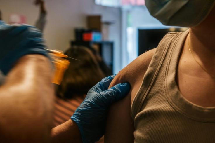 A volunteer administers a Covid-19 vaccine dose on May 13, 2021 in Houston, Texas, where healthcare workers at one hospital are suing it over a requirement they be inoculated