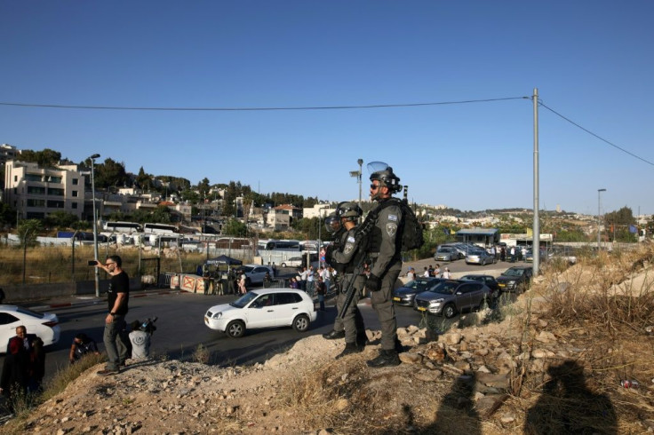 Israeli security forces watch as protesters near an Israeli police checkpoint at the entrance of the Sheikh Jarrah neighbourhood in east Jerusalem on May 29, 2021