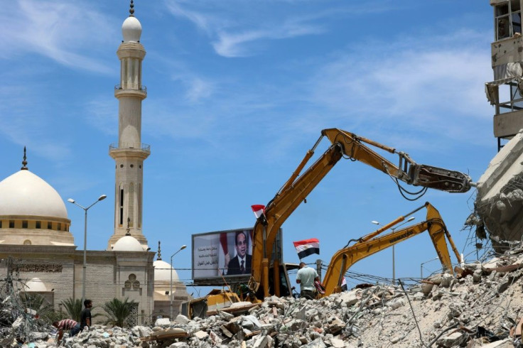 Egyptian workers use bulldozers to remove the rubble of Gaza City buildings destroyed by Israeli air strikes in this picture taken on June 8, 2021