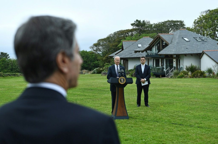 US Secretary of State Antony Blinken listens as US President Joe Biden makes a speech on the Covid pandemic, while Pfizer CEO Albert Bourla stands alongside him, in the Cornish town of St Ives ahead of the G7 summit