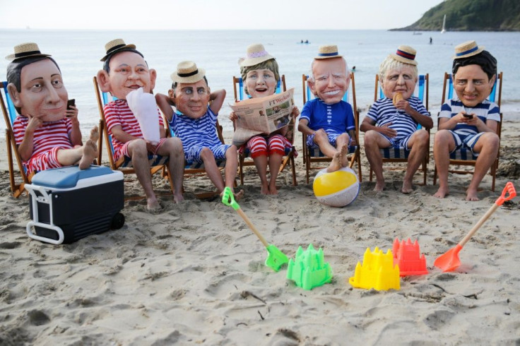 Oxfam activists wearing giant heads of the G7 leaders