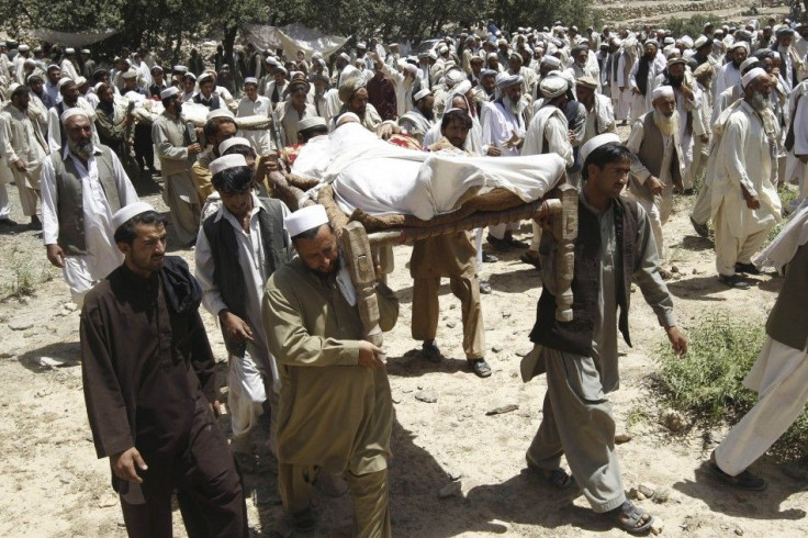 Afghan men carry bodies of people who were killed after insurgents attacked a wedding party in Dur Baba district