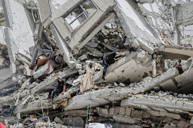 Palestinian workers clear the rubble and debris in Gaza City's Al-Rimal neighbourhood, which was targeted by Israeli strikes in May